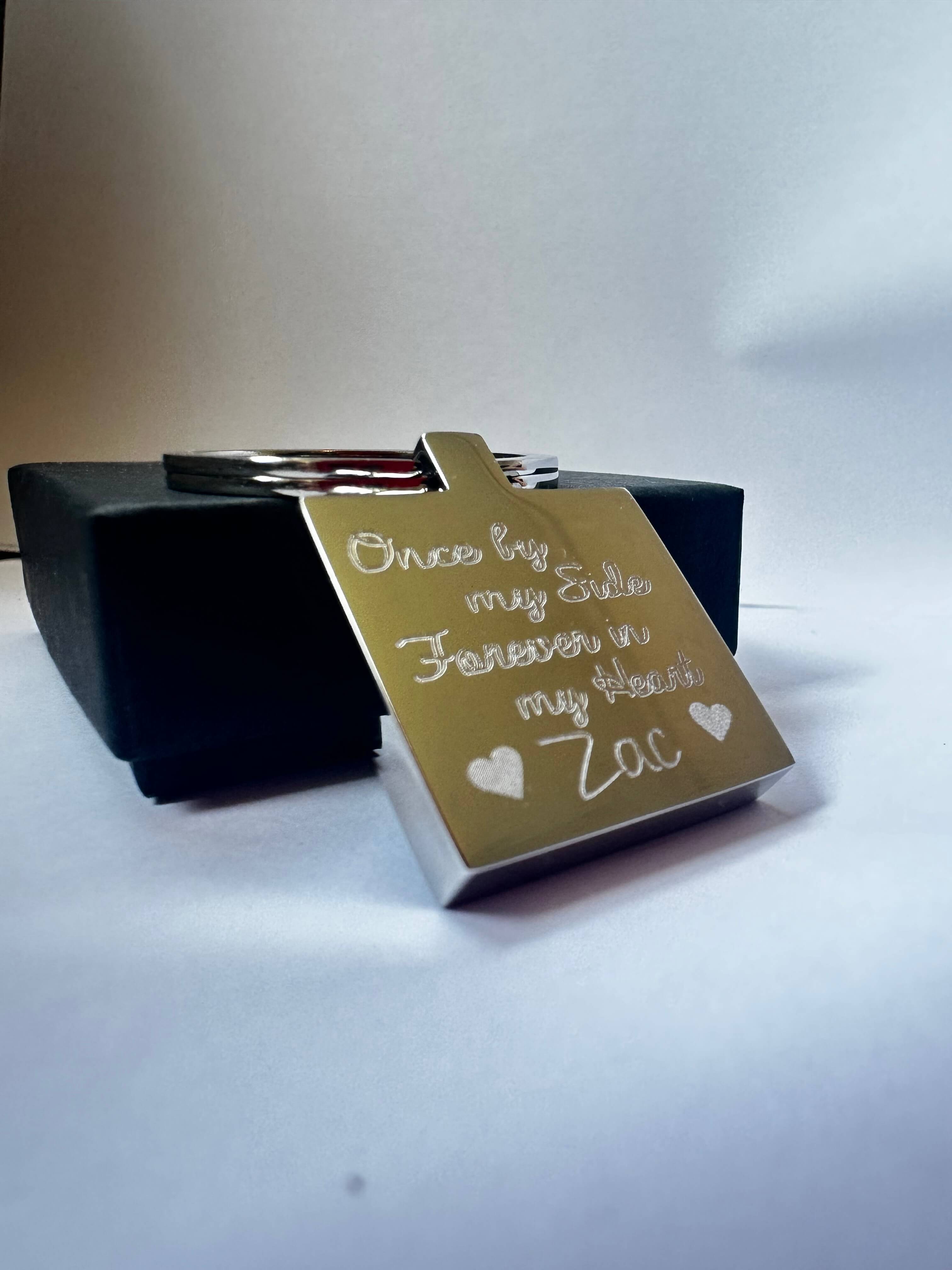 Stainless Steel square keychain with engraved text reading Once by my side forever in my heart.