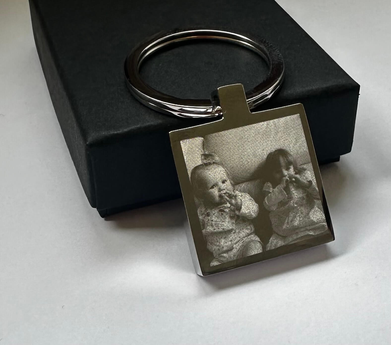 Keychain with a photo of two children on a white surface