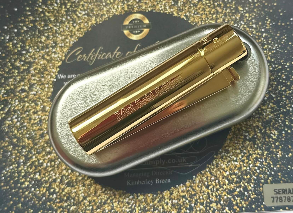 Gold clipper lighter in a metallic case on a glittery background